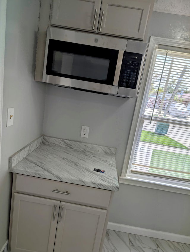 870 Capitol Ave, Lincoln Park, MI 48146 - detailed view of stainless steel microwave, baseboards, and white cabinets