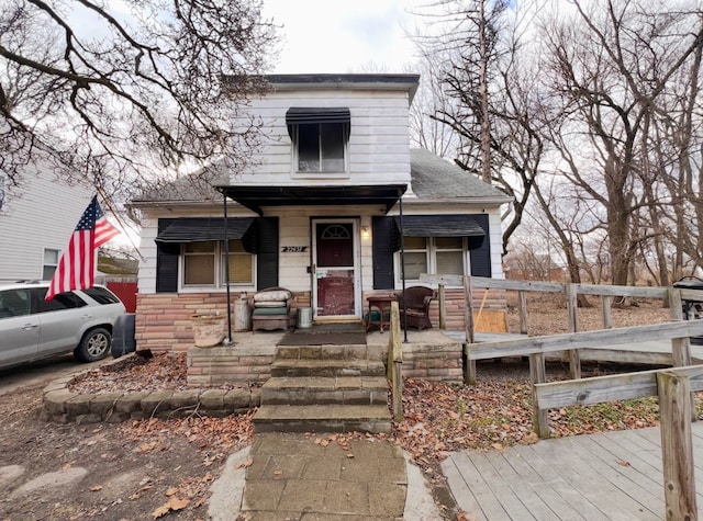 bungalow-style home featuring a porch and stone siding