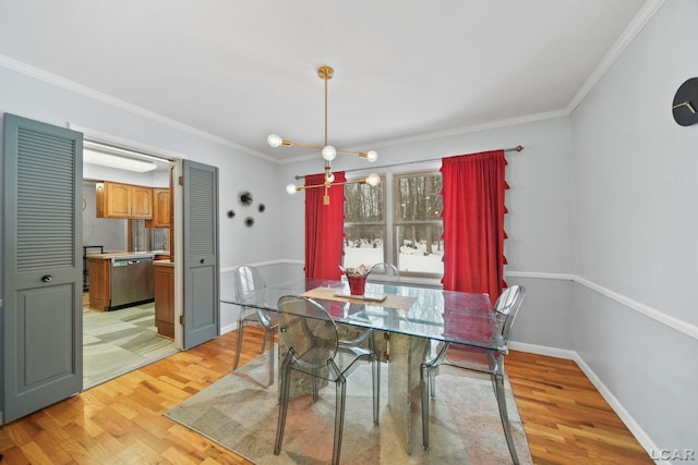 dining room featuring an inviting chandelier, crown molding, light wood-style flooring, and baseboards