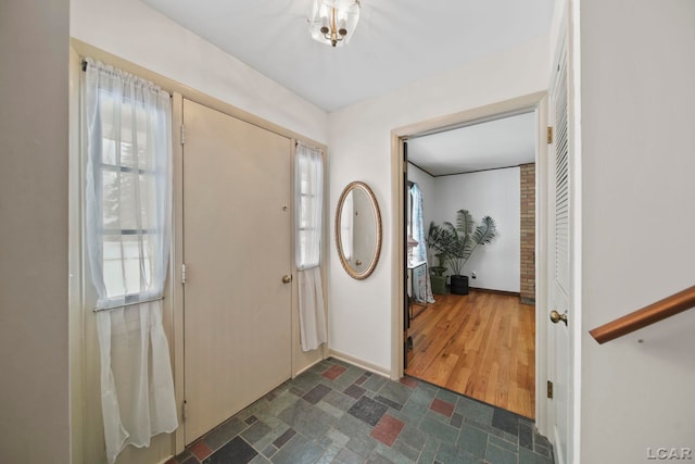 entrance foyer with stone finish flooring and baseboards