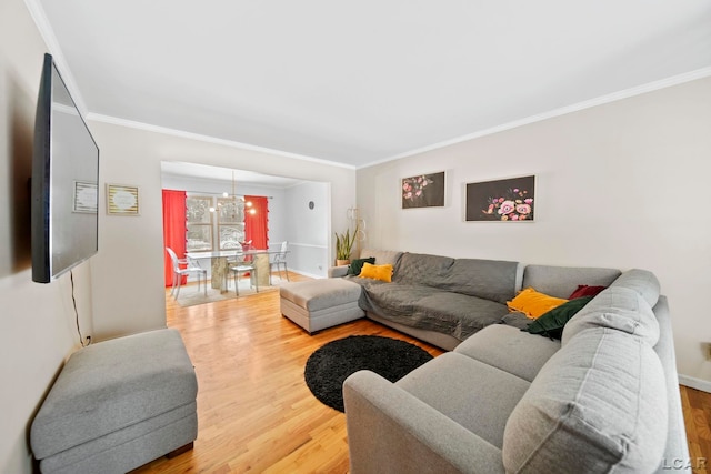 living area with a notable chandelier, wood finished floors, and ornamental molding