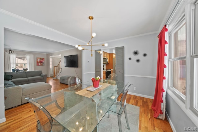 dining area featuring a notable chandelier, light wood-style flooring, stairway, crown molding, and baseboards