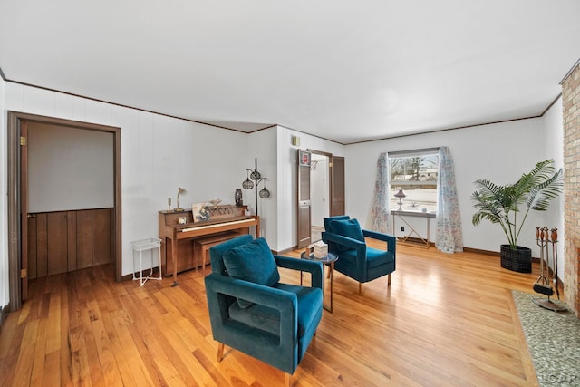 sitting room with light wood-style floors and ornamental molding