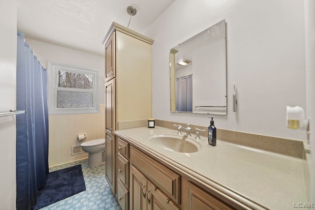 full bath featuring tile walls, tile patterned floors, toilet, and vanity