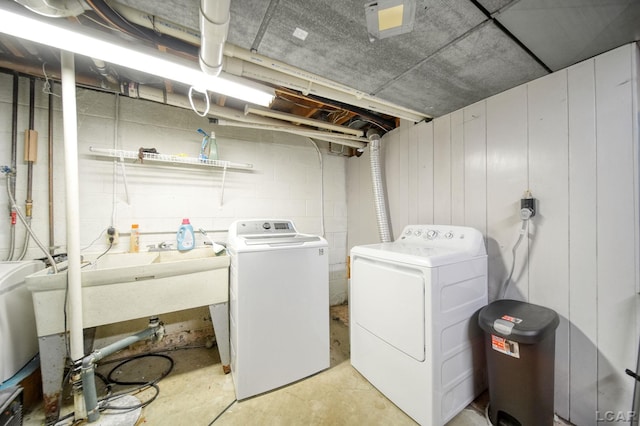 laundry room with concrete block wall, laundry area, and washer and clothes dryer