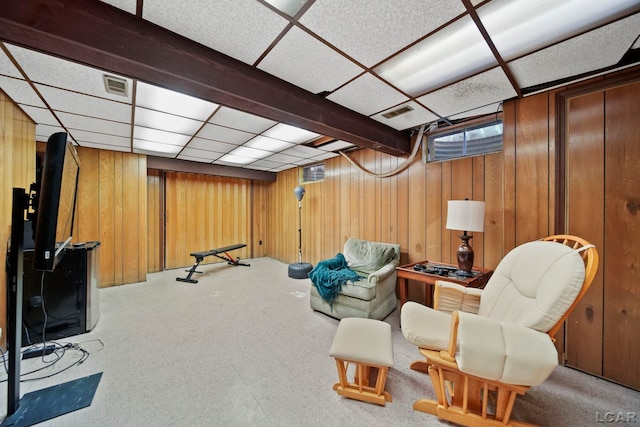 interior space featuring a drop ceiling, visible vents, and wood walls