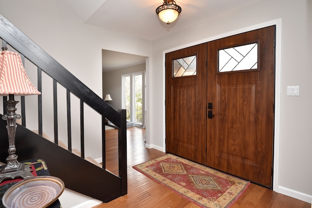 entrance foyer with stairs, baseboards, and wood finished floors