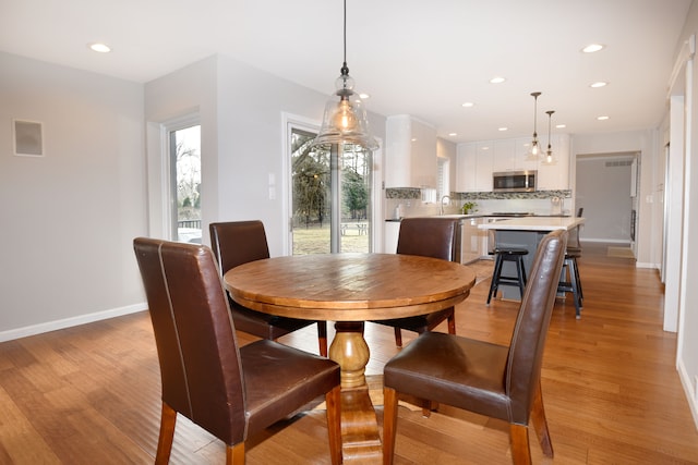 dining room featuring recessed lighting, light wood-style floors, and baseboards