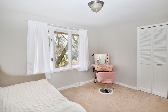 carpeted bedroom featuring visible vents, baseboards, and a closet