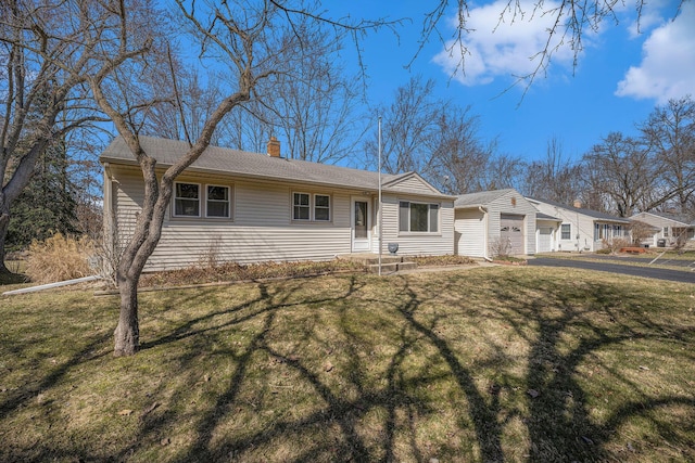 single story home featuring a front yard, a garage, and a chimney