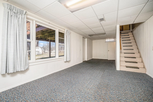 below grade area with visible vents, a paneled ceiling, carpet, and stairway