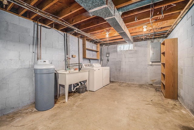 below grade area featuring electric panel and washing machine and clothes dryer