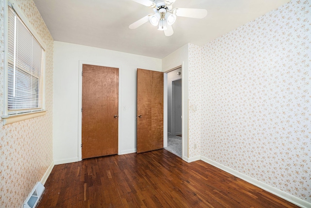 unfurnished bedroom with visible vents, wood finished floors, and wallpapered walls