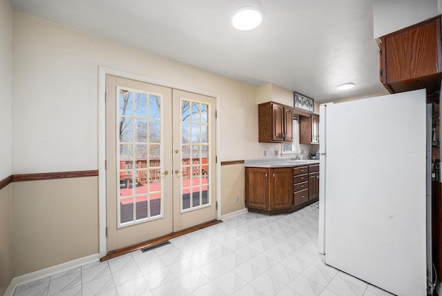 kitchen with visible vents, baseboards, freestanding refrigerator, light countertops, and french doors