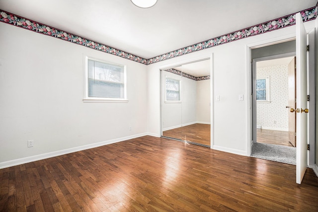 unfurnished bedroom with baseboards, wood-type flooring, and a closet