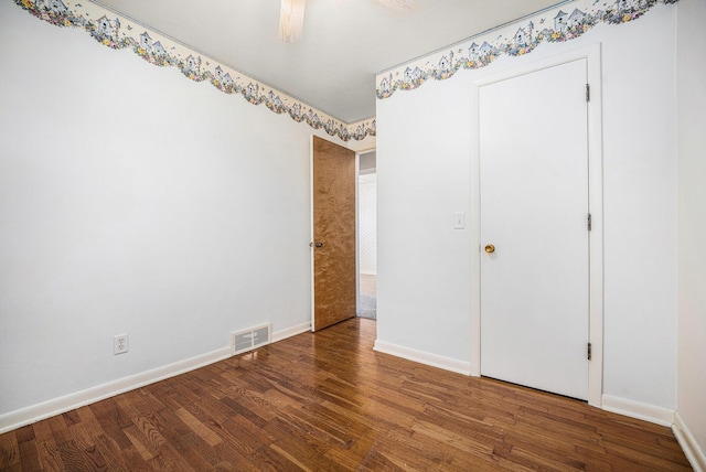 unfurnished bedroom with visible vents, a ceiling fan, baseboards, and wood finished floors