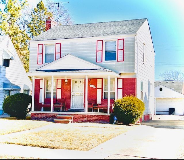 view of front of property with an outbuilding, covered porch, and a chimney