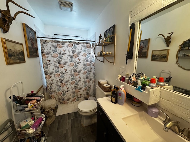 full bath featuring visible vents, toilet, curtained shower, wood finished floors, and vanity