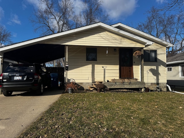 view of front of home with an attached carport, concrete driveway, and a front lawn