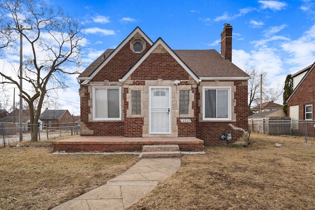 view of front of house with fence private yard, brick siding, roof with shingles, and a chimney