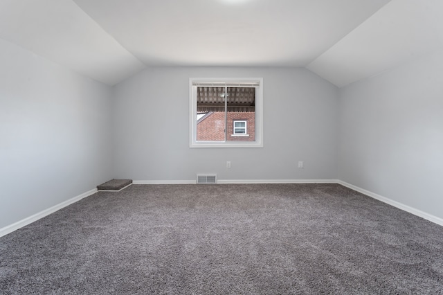 additional living space featuring visible vents, lofted ceiling, baseboards, and carpet flooring