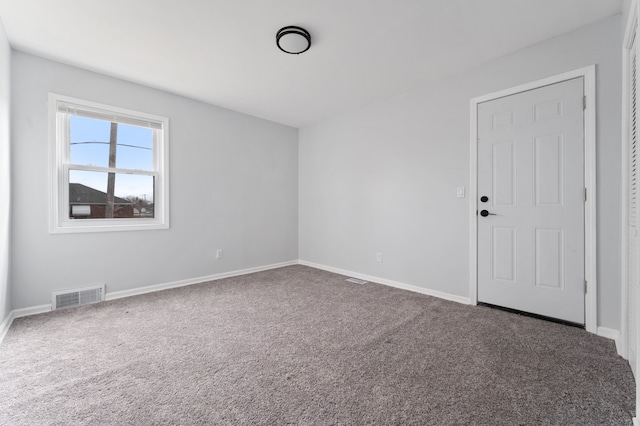 carpeted empty room featuring visible vents and baseboards