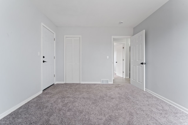 unfurnished bedroom with visible vents, baseboards, a closet, and carpet flooring