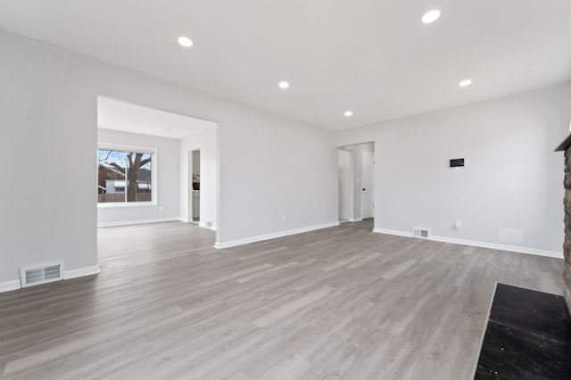 unfurnished living room featuring visible vents, recessed lighting, baseboards, and wood finished floors