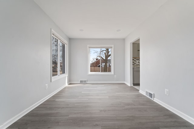 interior space with visible vents, baseboards, and wood finished floors