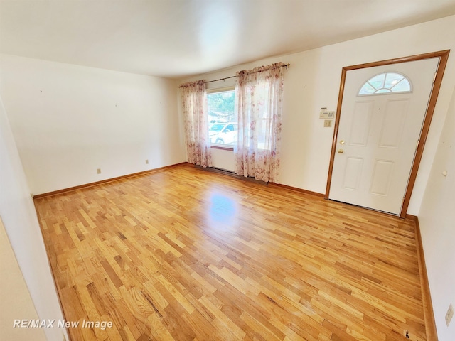 foyer entrance featuring light wood-type flooring and baseboards