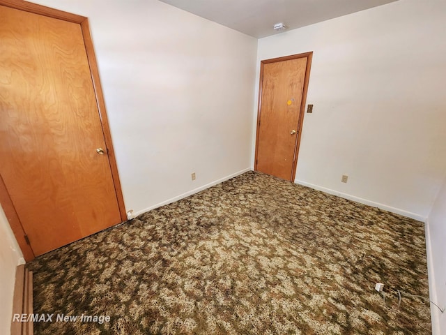 carpeted spare room with baseboards