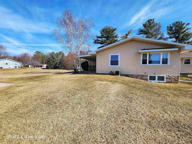 view of side of property featuring a yard and a carport