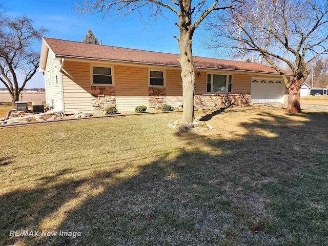 single story home with a garage, stone siding, and a front yard