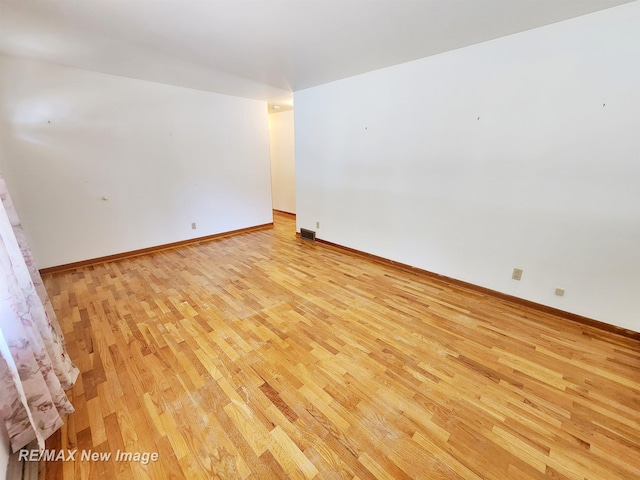 unfurnished room with visible vents, baseboards, and light wood finished floors