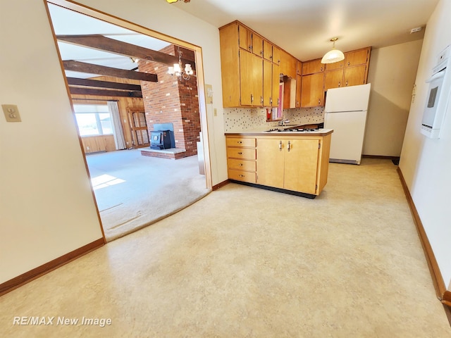 kitchen with decorative backsplash, white appliances, a wood stove, and baseboards