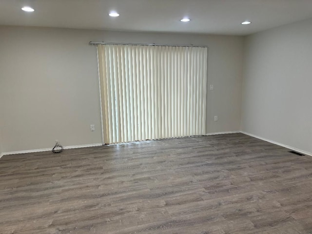 spare room featuring visible vents, recessed lighting, wood finished floors, and baseboards