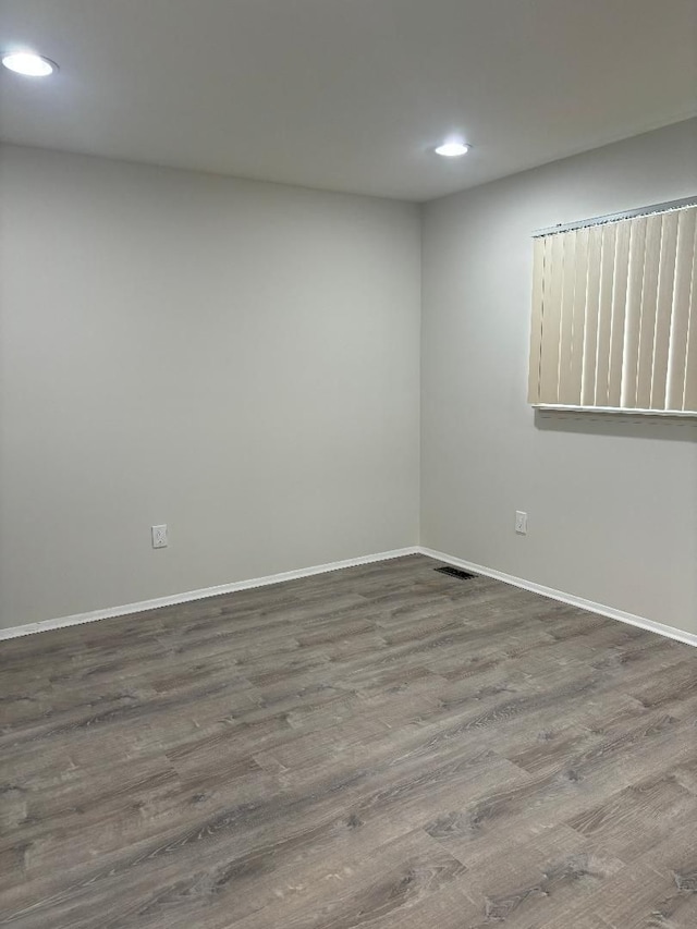 empty room featuring recessed lighting, wood finished floors, visible vents, and baseboards