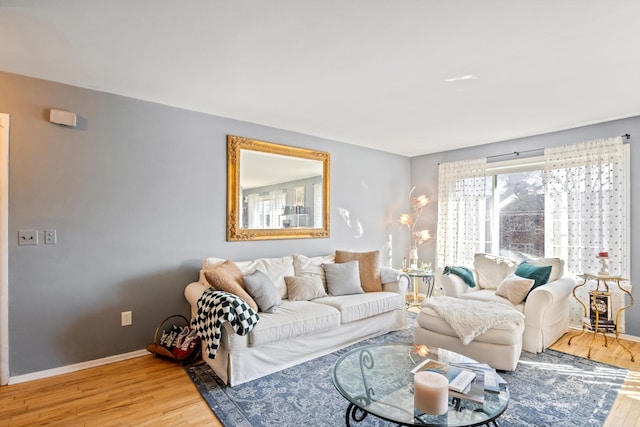 living area featuring baseboards and wood finished floors