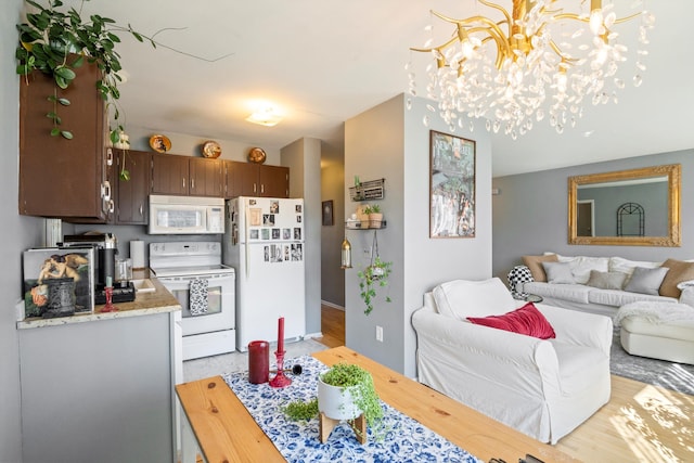 interior space with white appliances, a notable chandelier, light countertops, and open floor plan