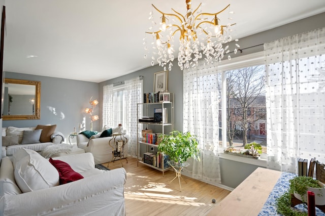 living area with a notable chandelier, a healthy amount of sunlight, and wood finished floors