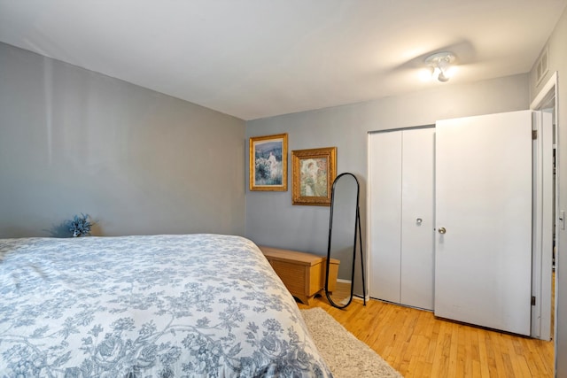 bedroom featuring a closet, visible vents, and light wood-type flooring