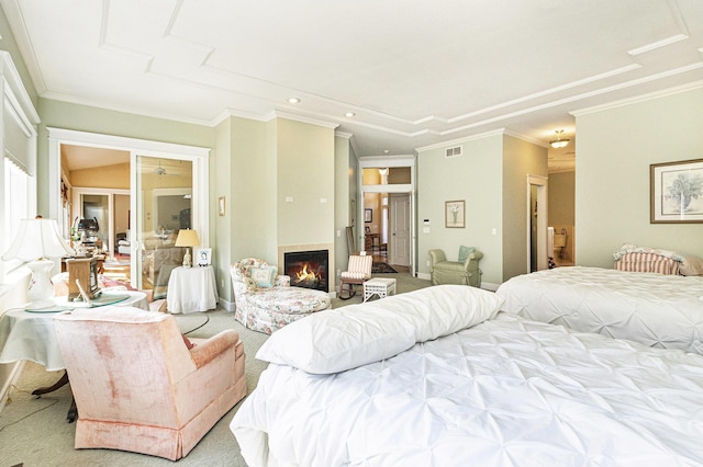 bedroom with carpet, visible vents, recessed lighting, a warm lit fireplace, and crown molding