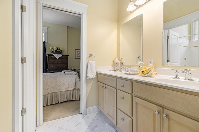 ensuite bathroom with double vanity, tile patterned floors, ensuite bath, and a sink