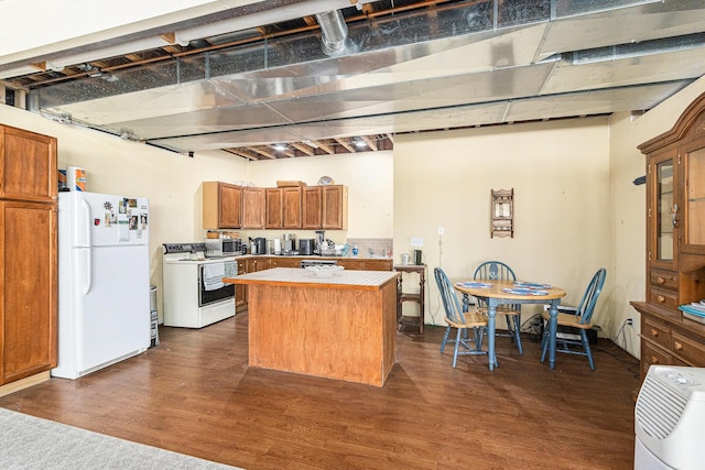 kitchen with white appliances, dark wood-style floors, brown cabinetry, a kitchen island, and light countertops