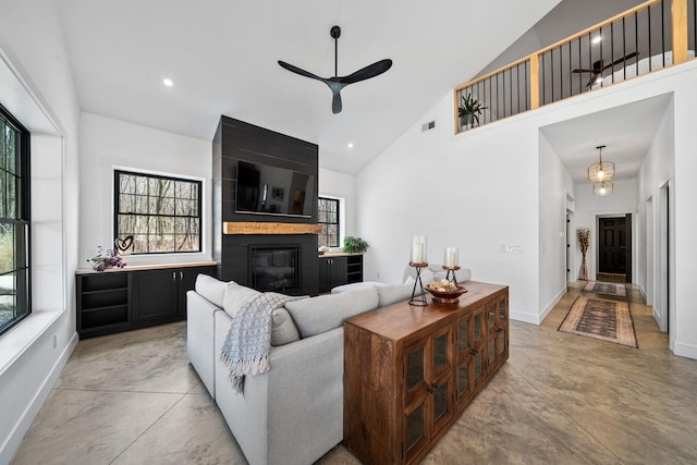 living room with high vaulted ceiling, a ceiling fan, finished concrete floors, recessed lighting, and a large fireplace