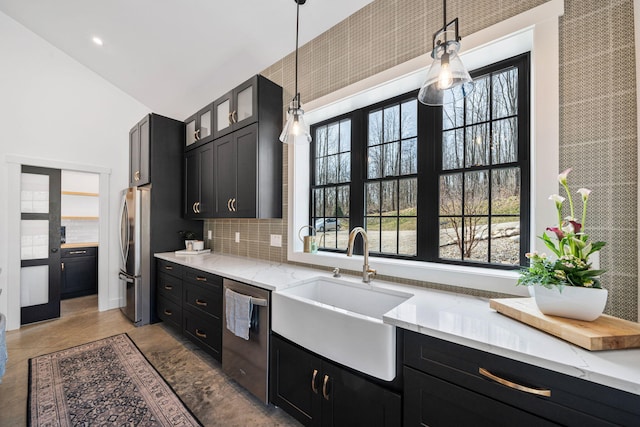 kitchen featuring a sink, a healthy amount of sunlight, appliances with stainless steel finishes, and dark cabinets