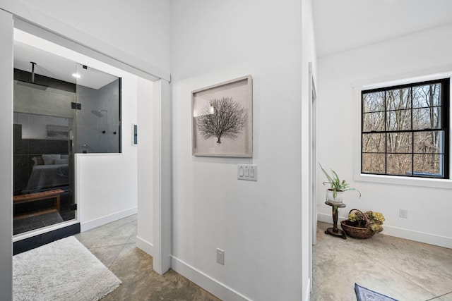 hall with baseboards and concrete floors