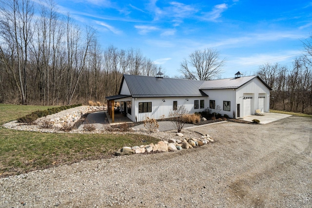 modern farmhouse featuring metal roof and dirt driveway