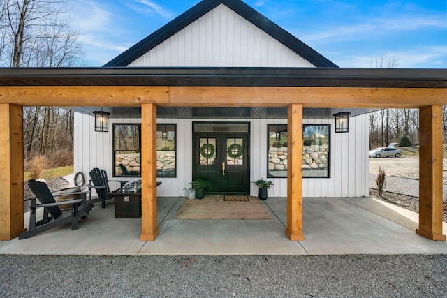 view of exterior entry featuring french doors and board and batten siding