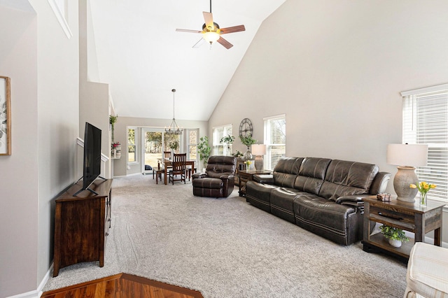 carpeted living area with baseboards, high vaulted ceiling, and a ceiling fan